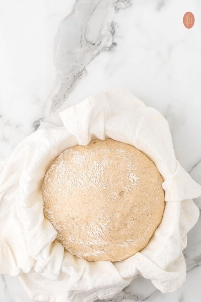 a dough in a bowl covered with towel.