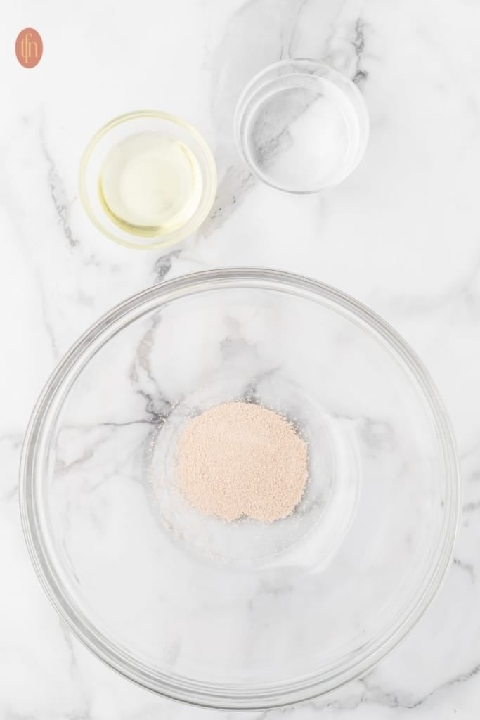 a bowl of active dry yeast, cooking oil and warm water.