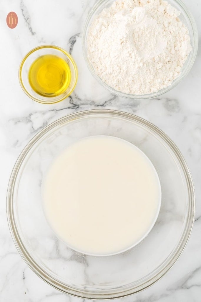 sourdough sandwich bread in glass mixing bowls.