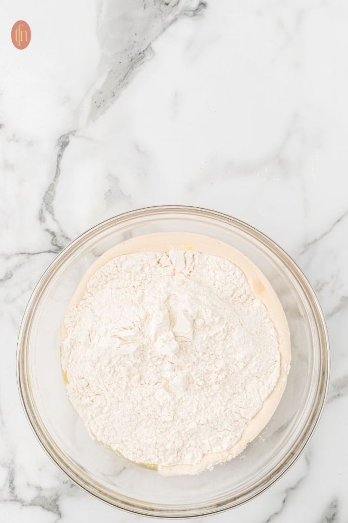 a bowl of all purpose flour and other ingredients for dinner rolls.