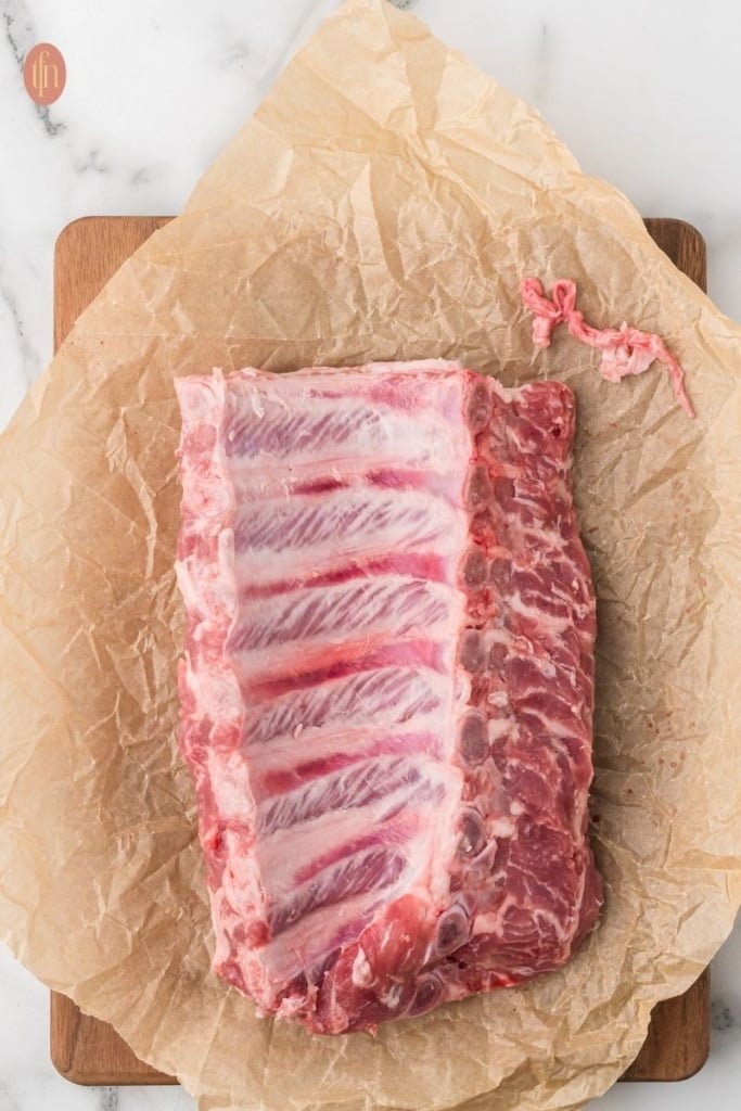 a raw pork ribs on a sheet of parchment paper.