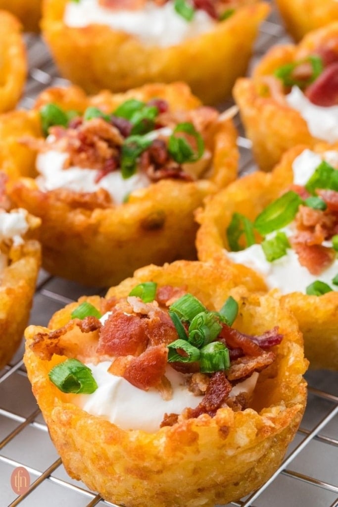 a close up shot of loaded tater tot cups.