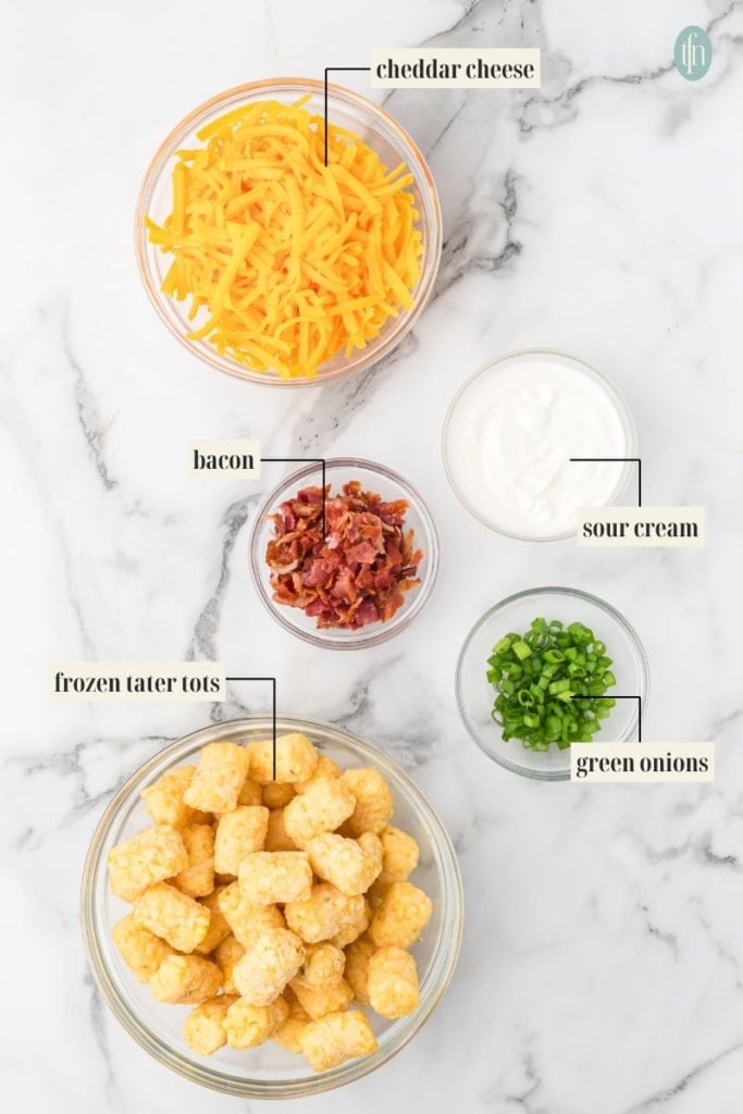 Loaded Tater Tot Cups Ingredient Image: cheddar cheese, bacon, sour cream, frozen tater tots and green onions.
