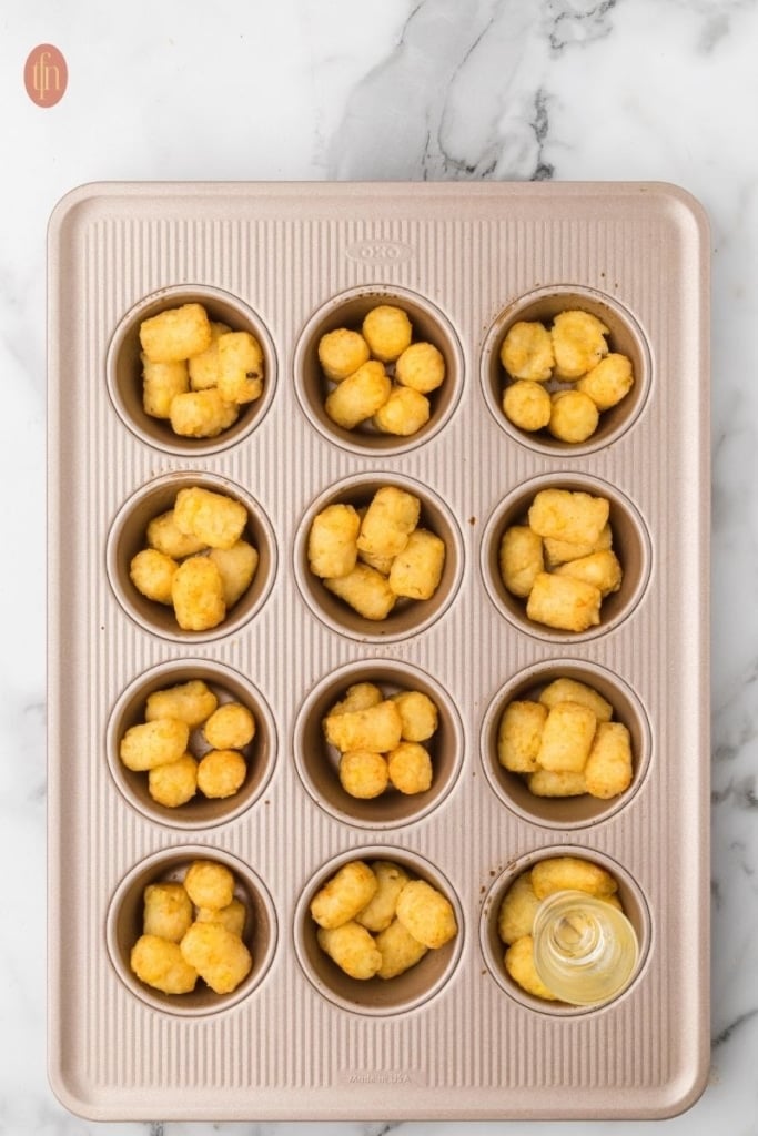 frozen tater tots on a muffin tin.
