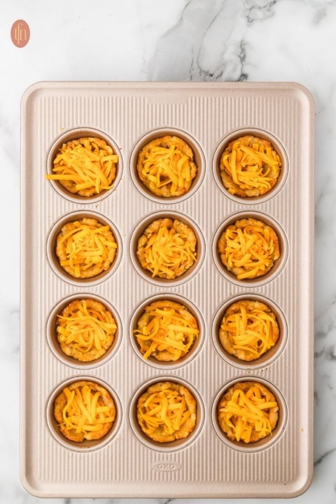 loaded tater tot cup prep on a muffin tin.