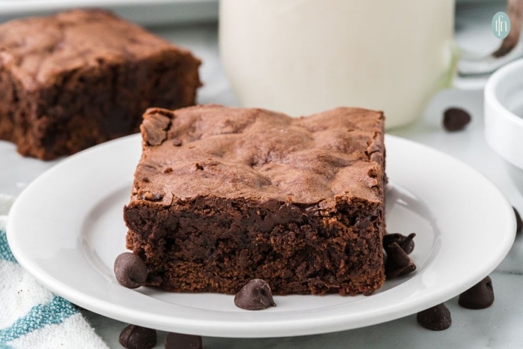 a plate of homemade brownies with chocolate chips.