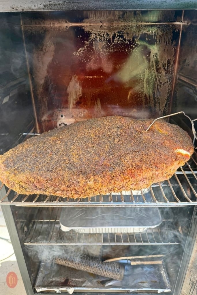 seasoned beef brisket inside a smoker.