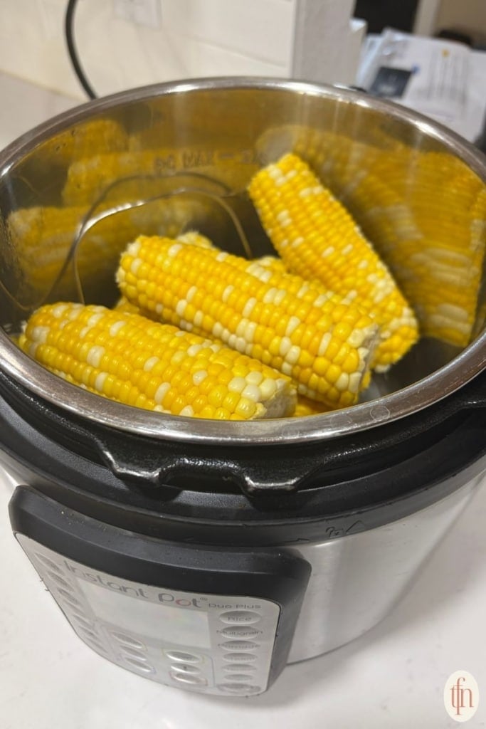 corn on the cob resting on the instant pot.