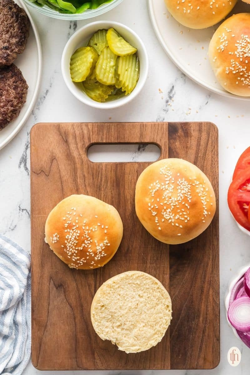 an image of Hamburger Buns on a wooden board.