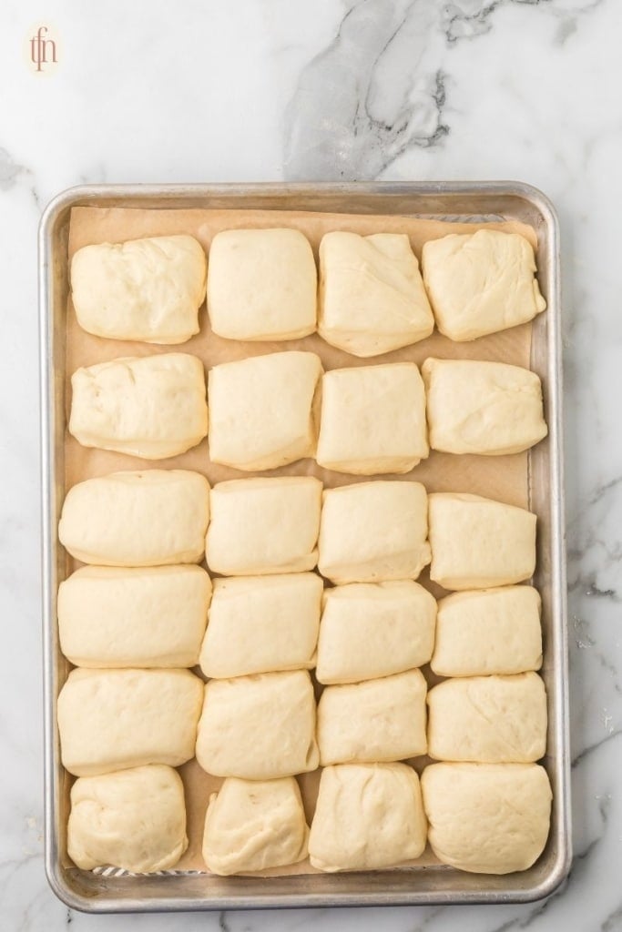 unbaked Texas Roadhouse Rolls on sheet.