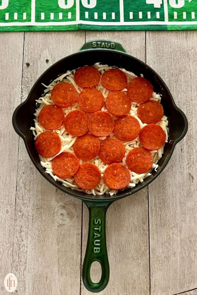 pepperoni layer over cheese in skillet.