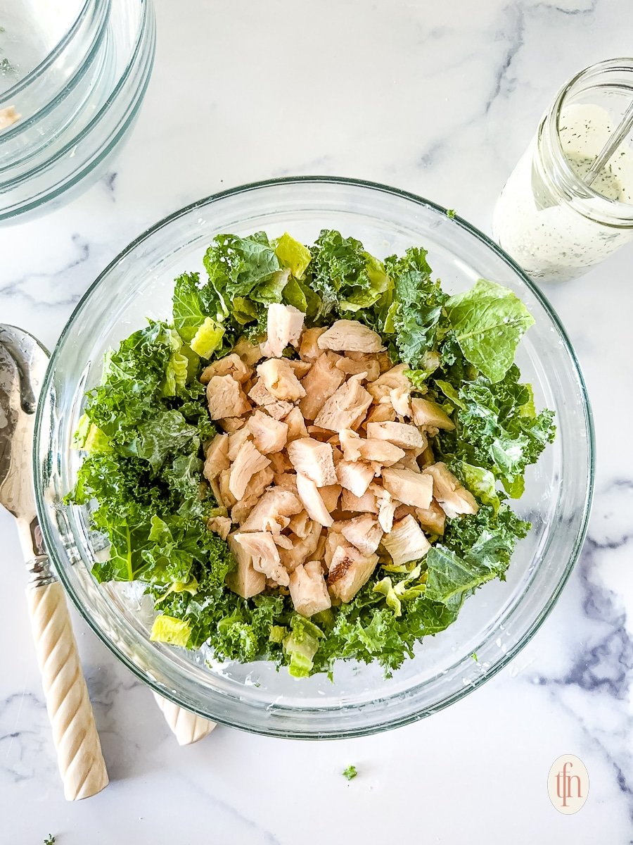 Lettuce and chicken in a glass bowl.