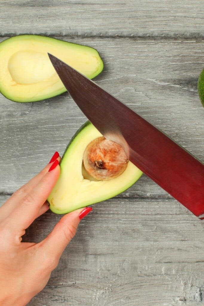 Removing the avocado seed with a knife